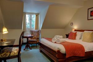 a bedroom with a bed and a desk and a chair at The Grange at Oborne in Sherborne +101 photos