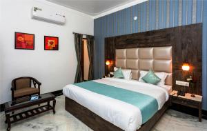 ein Schlafzimmer mit einem großen Bett und einem Stuhl in der Unterkunft Hotel Castle Inn in Udaipur