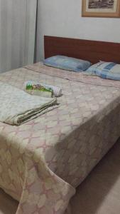 a bed with a pink and white quilt on it at Casa Blumenau in Blumenau