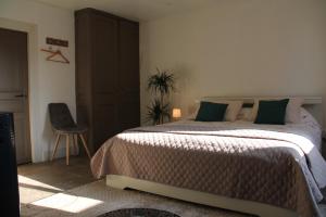 a bedroom with a large bed and a chair at La Cour d'Enchère in Saint-Palais +33 photos