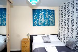 a bedroom with a bed and a painting on the wall at RICHFLO Facility Rentals in Manchester