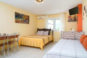 a bedroom with a bed and a table and a window at Thomas Apartments in Skala Marion