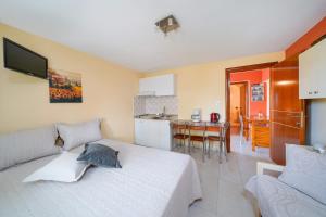 a bedroom with a white bed and a kitchen at Thomas Apartments in Skala Marion