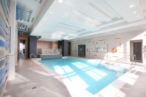 a large swimming pool in a building at Royal Stays Furnished Apartments - Square One in Mississauga