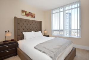 a bedroom with a large bed and a large window at Royal Stays Furnished Apartments - Square One in Mississauga