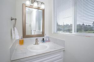 uma casa de banho branca com um lavatório e um espelho em Mother in Law Suite with Private Hot Tub--Downtown em North Bend