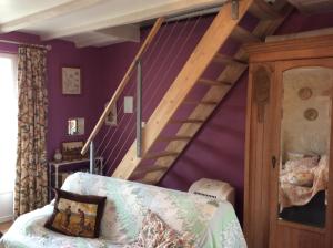 ein Wohnzimmer mit lilafarbenen Wänden und einer Treppe in der Unterkunft Papillon in Esves-le-Moutier