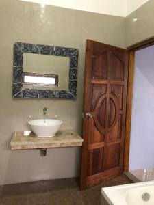 a bathroom with a sink and a wooden door at Marie'z Villa in Tuktuk Siadong +52 photos