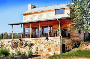 a log cabin with a balcony on a stone building at Hideout on the Horseshoe in Canyon Lake