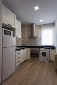 a kitchen with white cabinets and a washer and dryer at Con encanto y bien ubicado in Logroño
