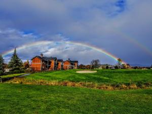 a rainbow in the sky over a house at Resort at Eagle Point Golf Club Lodging in Medford