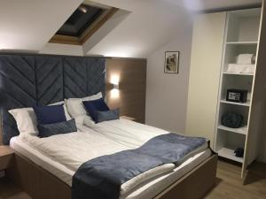 una camera da letto con un grande letto con cuscini blu di Sleep Inn Prishtina a Pristina