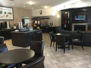 a restaurant with tables and chairs and a fireplace at Ramada by Wyndham Brooks in Brooks