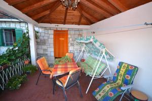 une terrasse couverte avec une table et des chaises. dans l'établissement Apartments Kat - 80 m from beach, à Splitska