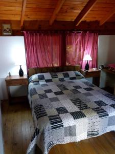 a bedroom with a black and white quilt on a bed at Bicicleteria Don Perez in San Isidro