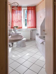 a bathroom with two sinks a toilet and a tub at Hotel Italia in Aumühle