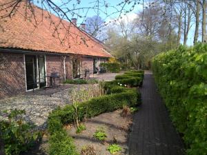 un jardin en face d'une maison en briques dans l'établissement Bed & Breakfast Uiterburen, à Zuidbroek