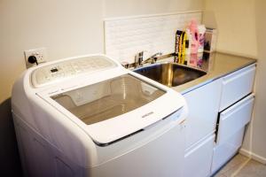eine Waschmaschine in einer Küche neben einer Spüle in der Unterkunft Queenstown Villa with Amazing Lake Views & floor heating 湖景别墅 & 地暖 in Queenstown + 28 Fotos