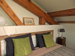 a bedroom with a bed with green and blue pillows at Le Plateau de la Danse in Saint-Victor-sur-Loire