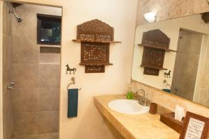 y baño con lavabo, espejo y ducha. en Private Bungalow @ Bacalar 7 Colors Lagoon en Bacalar