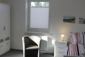 1 dormitorio con silla y ventana en 3 Zimmer Ferienwohnung - Woltorf, en Peine