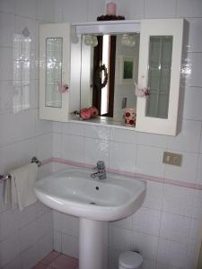 a white bathroom with a sink and a mirror at B&B Nautilus in Puegnago