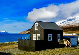 a small house on the side of a body of water at Vellir Grenivík Home with a View in Grenivík