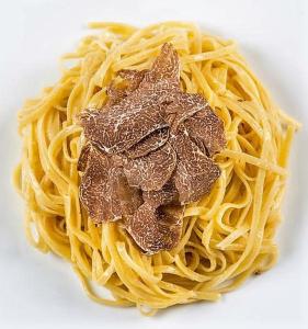 einen Haufen Pasta mit Fleisch auf einem weißen Teller in der Unterkunft Cà Maggio Nuovo in Acqualagna