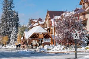 a building covered in snow with people walking in the street at Banff Caribou Lodge and Spa in Banff