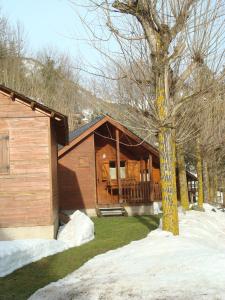 a log cabin with a tree in front of it at Camping Forcanada in Era Bordeta