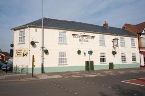 a white building on the corner of a street at Castle Limes Hotel in Warwick