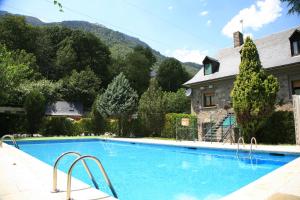 a large swimming pool in front of a house at Camping Forcanada in Era Bordeta