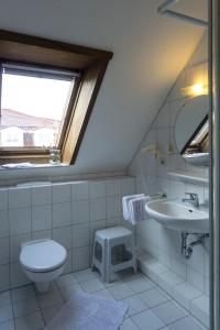 La salle de bains est pourvue de toilettes, d'un lavabo et d'une fenêtre. dans l'établissement Pension Appartementhaus Hus Möhlenbarg, à Cuxhaven