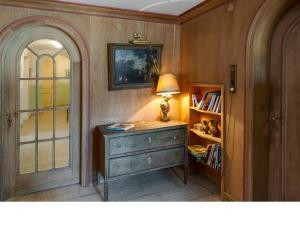 a room with a desk with a lamp and a book shelf at Hotel Italia in Aumühle