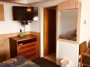 a room with a bedroom with a bed and a mirror at North Country American Inn in Kalkaska