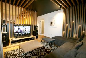 ein Wohnzimmer mit einem Sofa und einem Flachbild-TV in der Unterkunft Apartment Gotham in Belgrad