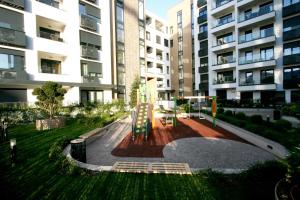 einem Park vor einem großen Apartmenthaus in der Unterkunft Apartment Gotham in Belgrad