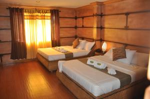 sypialnia z 2 łóżkami i oknem w obiekcie Bosay Resort w mieście Antipolo