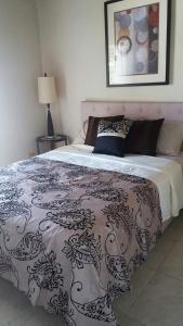 a bedroom with a bed with a black and white blanket at Private Garden Suite, Surf, Work, Relax in Christ Church