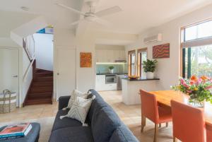 a living room with a blue couch and a table at The Crest Byron Bay in Byron Bay