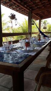 a long table with plates and glasses on it at Casa de Praia Natal in Nísia Floresta