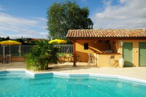a house with a swimming pool in front of a house at Logis Hotel Des Grands Vins in Fleurie