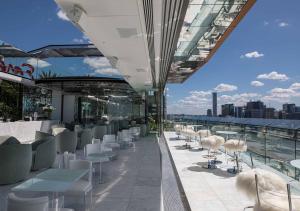 a patio area with tables, chairs and umbrellas at Emporium Hotel South Bank in Brisbane