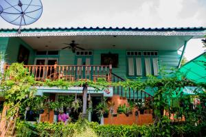 een groen huis met een balkon en een ventilator bij Samsen Sam Place in Bangkok