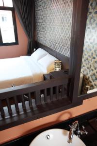 a bathroom with a bed and a sink and a mirror at Rambuttri Village Plaza in Bangkok