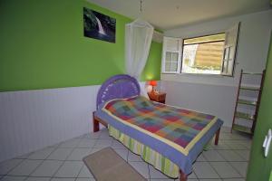 a small bedroom with a bed and a window at CHEZ JOJO in Sainte-Anne