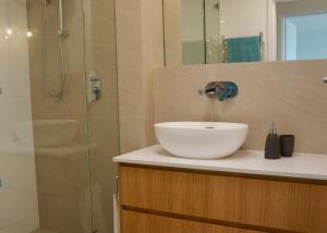a bathroom with a sink and a shower at Cottesloe Beachfront Ocean View Apartment in Perth +15 photos