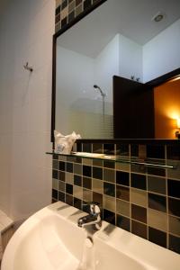 baño con lavabo y espejo grande en Hostal Real, en San Juan del Puerto
