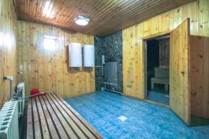 an empty room with a bench in a room with wooden walls at ToodoResort in Karakol