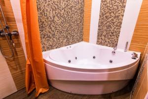 a bath tub in a bathroom with a shower at Apartment Hotel in Blagoveshchensk